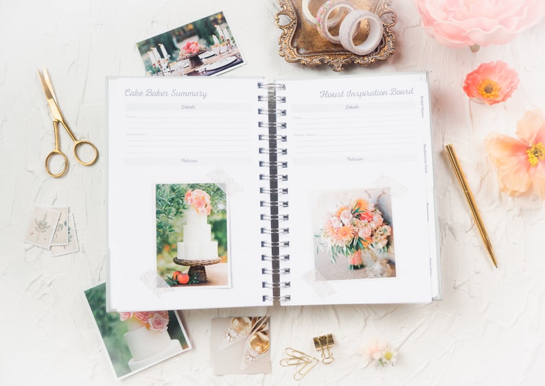 Puede incluir: Un planificador de bodas abierto con los t&iacute;tulos "Cake Baker Summary" y "Florist Inspiration Board". La imagen incluye fotos de pasteles y flores, tijeras doradas, un bol&iacute;grafo dorado y cinta decorativa. El tema es la planificaci&oacute;n de bodas.