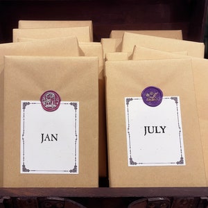 May include: A wooden chest with a stack of brown paper packages. The packages are sealed with wax seals, one red and one purple. The packages are labeled "JAN" and "JULY".