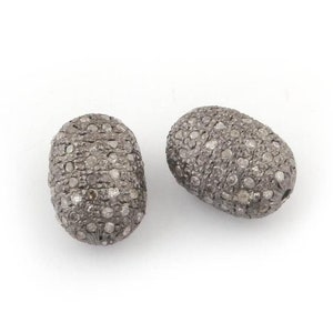 May include: Two oval-shaped beads with a silver finish and a textured surface covered in small, clear diamonds.