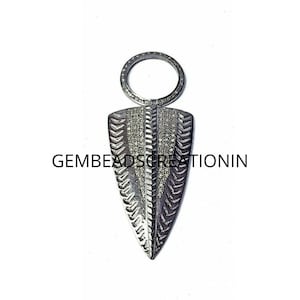 May include: Silver pendant featuring a diamond-encrusted arrowhead design and a circular bail. The pendant measures approximately 5 cm in length.