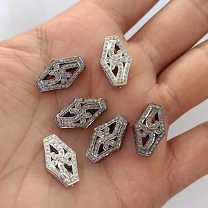 Puede incluir: Seis colgantes hexagonales de plata y negro con un patrón de diamante y un diseño floral.