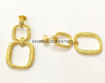 May include: Gold-tone earrings with a textured square link design. The earrings are made of two linked squares.