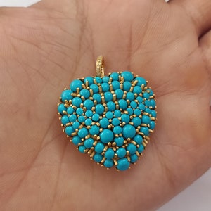 May include: A gold heart-shaped pendant with a cluster of turquoise stones and small diamonds.