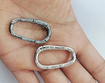 May include: Two oval-shaped metal key rings. One is silver and the other is black.