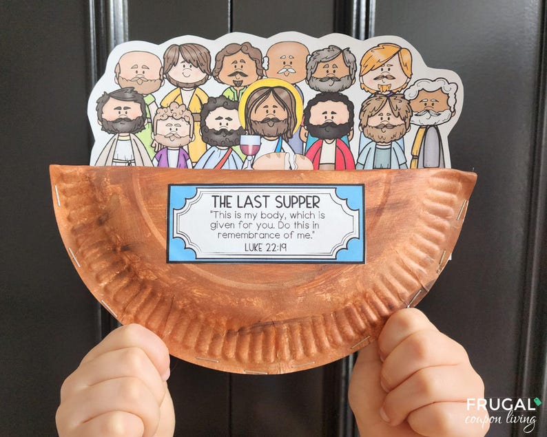 May include: A brown paper plate with a white border and a blue and white sign that reads "The Last Supper" with the Bible verse Luke 22:19. The sign is attached to the plate with a stapler. There are 12 cartoon figures of men around the edge of the plate. The figures are all wearing different colored clothing and have different facial expressions.