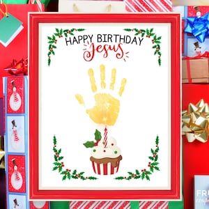 May include: A framed print with a red border, featuring the text "HAPPY BIRTHDAY Jesus" above a yellow handprint. Below the handprint is a cupcake with a lit candle and holly. The print is surrounded by Christmas-themed gift boxes.