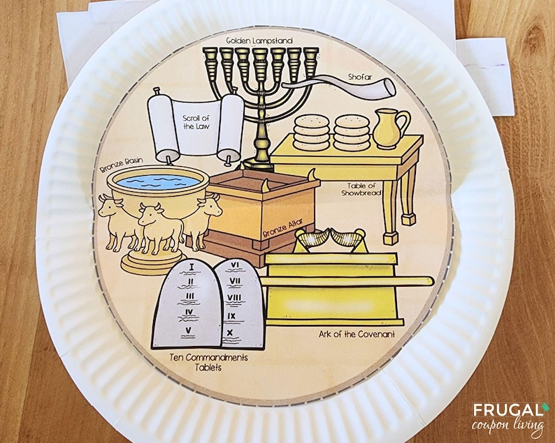 May include: A paper plate with a circular illustration depicting religious symbols. The illustration includes a golden lampstand, a scroll, a bronze basin, and the Ten Commandments tablets. The text "Golden Lampstand", "Scroll of the Law", and "Ten Commandments Tablets" are visible.