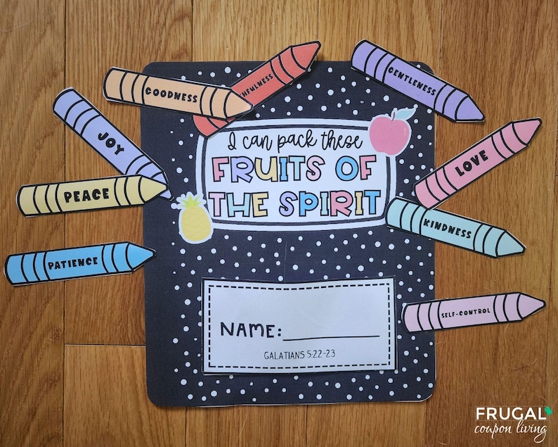 May include: A black notebook with white polka dots and the text "I can pack these FRUITS OF THE SPIRIT." Colourful crayon cutouts spell out words like "Joy," "Peace," and "Love." A pineapple and apple sticker are also included.