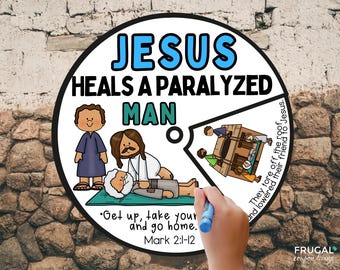 May include: A circular illustration with the text "JESUS HEALS A PARALYZED MAN." The image depicts Jesus healing a man, with additional figures and text from Mark 2:1-12. A hand holding a blue marker is in the foreground.