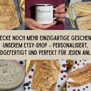 May include: A selection of engraved wooden boards and a white enamel mug with the name "Mareen". The boards are for serving food and have personalized designs. The image also includes text in German.