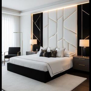 Op de afbeelding: Een moderne slaapkamer met een zwart bedframe, wit beddengoed en decoratieve kussens. Het hoofdbord heeft een geometrisch ontwerp met zwarte, witte en gouden accenten. Twee nachtkastjes met lampen flankeren het bed. Een zwarte stoel en een vloerlamp zijn ook zichtbaar.