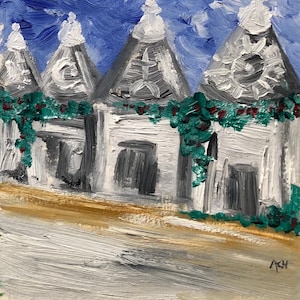 May include: An acrylic painting depicting white buildings with conical roofs, decorated with green foliage and red berries. The buildings are set against a blue sky, with a light brown road in the foreground. The artwork is signed in the bottom right corner.