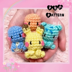 Op de afbeelding: Vier gehaakte amigurumi knuffels in verschillende kleuren: blauw, geel, oranje en groen. De knuffels hebben de vorm van cartoonfiguren met grote ogen en glimlachende gezichten. De afbeelding bevat de tekst "PDF PATTERN miki".