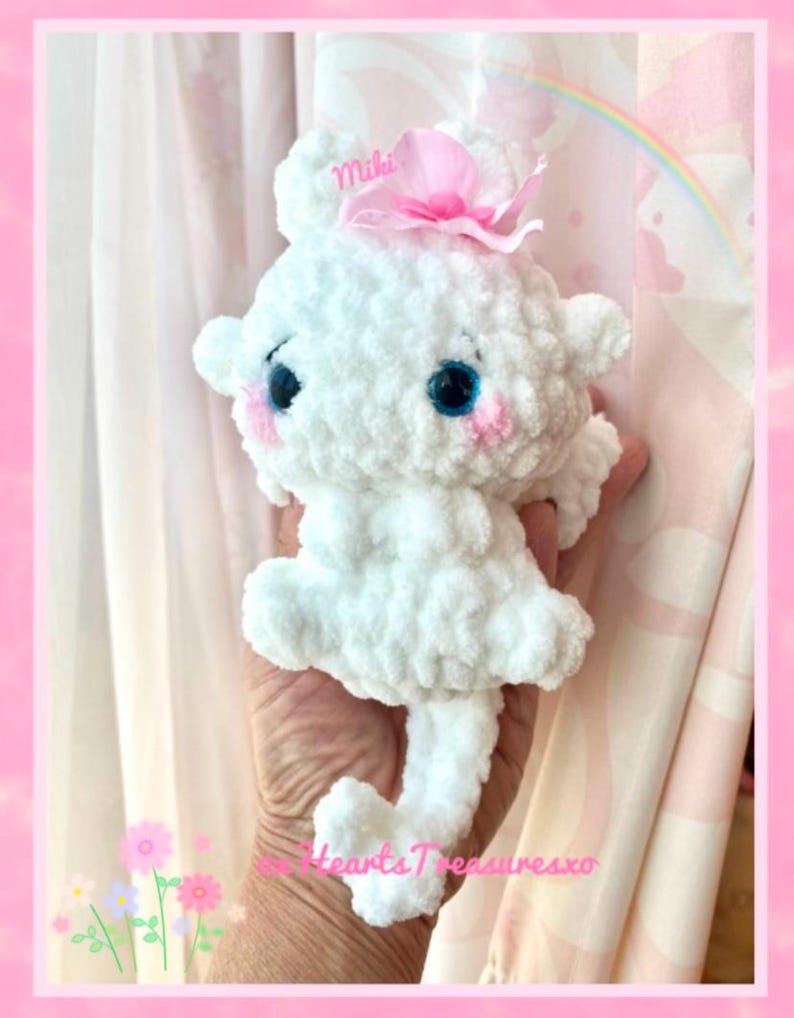May include: White crocheted plush toy with pink bow and blue eyes. The toy is named "Miki" and is holding a heart-shaped tail.