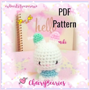 May include: A crochet amigurumi bunny pattern in PDF format. The bunny is white with light blue and pink accents. The pattern is titled "hello" and is available for download. The image also includes the text "CheeryBearies" and "miki".