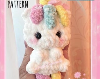 May include: A crocheted unicorn amigurumi toy with a white body, pink, blue, and yellow yarn for the mane and tail, and black eyes. The toy is being held in a hand. The text "PDF PATTERN" and "LOW SEW" is visible in the image.
