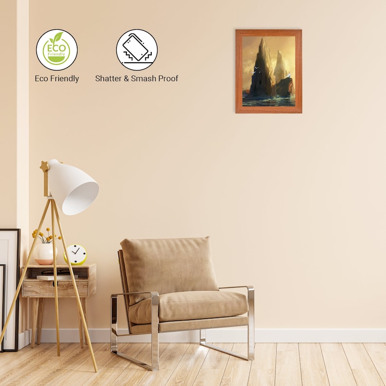 Puede incluir: Una pintura de paisaje enmarcada de dos islas rocosas con un marco de madera. La pintura est&aacute; colgada en una pared beige en un ambiente de sala de estar con un sill&oacute;n marr&oacute;n y una l&aacute;mpara de pie.