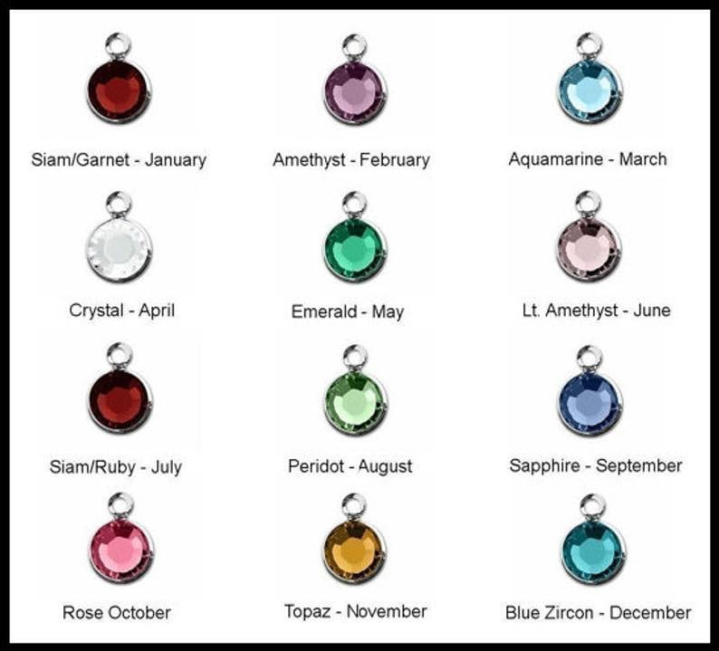 May include: Twelve round gemstone charms, each representing a different month of the year. The charms are silver with a clear crystal, red, pink, blue, green, and brown gemstones.