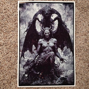 May include: A print featuring a demonic figure with horns, wings, and a skeletal face, seated amidst dark, swirling forms. The artwork is rendered in shades of gray and black, with a dramatic, ominous atmosphere. Lightning bolts streak across the background.