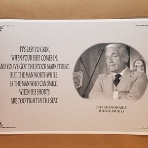 May include: Black and white print featuring a portrait of Judge Smails with a quote about smiling in difficult situations. The print has decorative corner elements and text that reads "IT'S EASY TO GRIN...ARE TOO TIGHT IN THE SEAT."