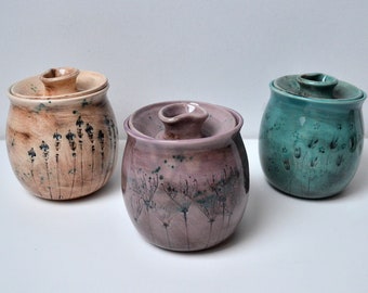 蜂蜜の瓶、手作りの陶器のキッチン収納、野生の花で飾られた