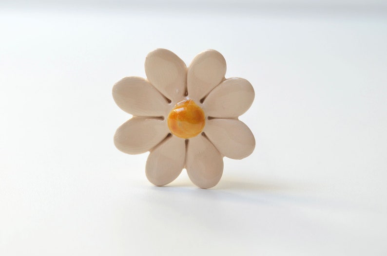 ceramic daisy

Colourfull, hand-made, lovely ceramic daisy, avaiable in 7 colours. They are fixed on a green wire stem (l=20cm), you can put them in a vase, next to your inside plant or outside in the garden.