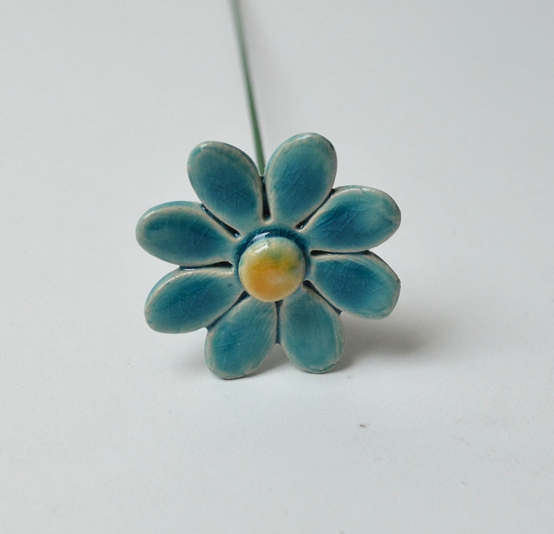 Colourfull, hand-made, lovely ceramic daisy, avaiable in 7 colours. They are fixed on a green wire stem (l=20cm), you can put them in a vase, next to your inside plant or outside in the garden.