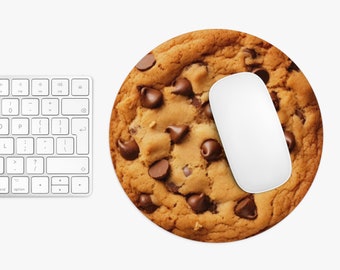 May include: A round brown chocolate chip cookie mouse pad with a white computer mouse on top.