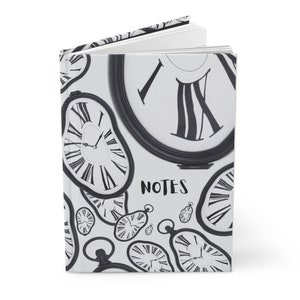 May include: A white notebook with a black and white design of melting clocks. The cover has the word "NOTES" printed in black.