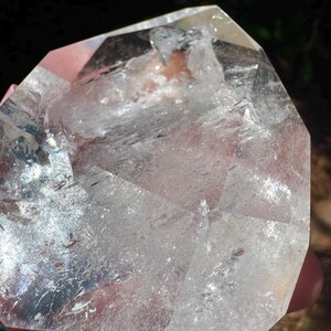 May include: A white ceramic mug with a black handle and the text "But First, Coffee" in a bold, black font. The mug is set against a blurred background, suggesting a cosy setting.