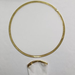 May include: A white circle with a gold border. The circle is surrounded by a white background.