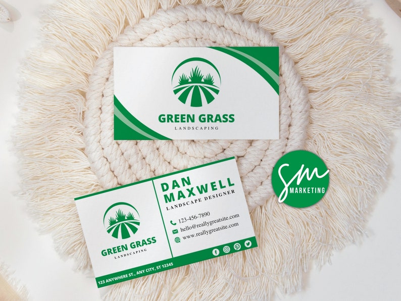 May include: Two business cards for Green Grass Landscaping. The top card features a green logo of a field of grass with a white background. The bottom card features a green logo of a field of grass with a white background and the text "Dan Maxwell Landscape Designer" and contact information.