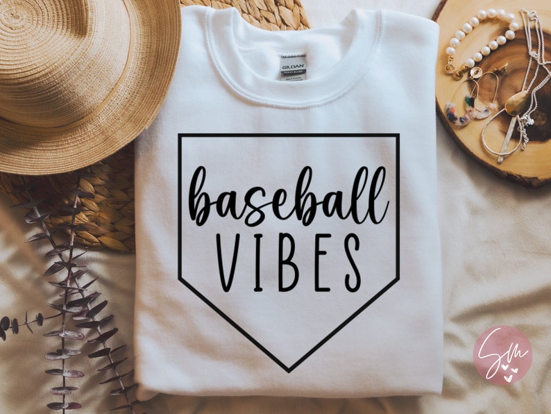 May include: White sweatshirt with a black baseball diamond graphic and the text "baseball vibes" in black script.