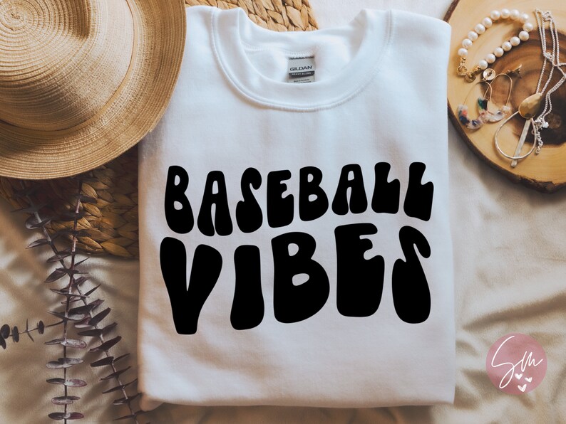 May include: White sweatshirt with the text "BASEBALL VIBES" in black, retro-style lettering.