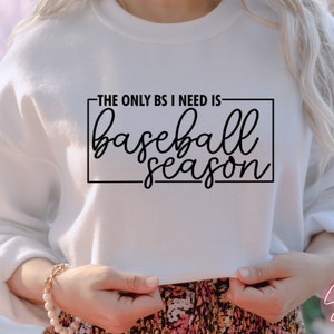 May include: White sweatshirt with black text that reads "The only BS I need is baseball season".