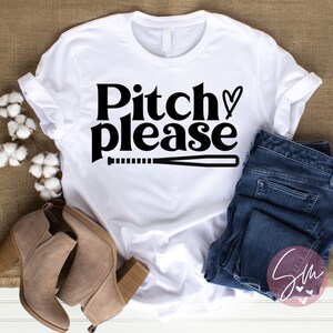 May include: White t-shirt with black text that says "Pitch please" with a baseball bat and a heart symbol.