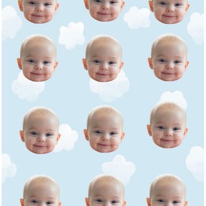 Könnte beinhalten: Ein sich wiederholendes Muster von Babygesichtern auf hellblauem Hintergrund mit weißen Wolken. Die Babys lächeln alle und haben helle Haut.