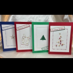 Hand stitched Christmas cards. Pack of 4 cards, mixed designs. Includes a star, a present and 2x Christmas trees, one with sparkling gems