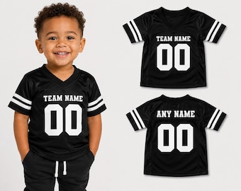 May include: A black V-neck jersey with short sleeves featuring two white stripes on each sleeve. The front displays the text TEAM NAME above the number 00 in white. A second view shows the back with the text ANY NAME above the number 00 in white.