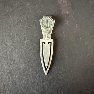 May include: A silver-colored bookmark with a decorative top featuring the text "Ruby Falls Lookout Mt. Tenn." The bookmark has a textured handle and a pointed, elongated design.