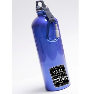 May include: Blue water bottle with a black and white sticker that says "Why Y'all Trying to Test the Beth Dutton in Me."