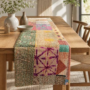 May include: A rectangular table runner featuring a patchwork design of various fabric squares in shades of green, pink, yellow, and orange. The textile displays intricate white kantha stitching throughout, creating a textured surface pattern.