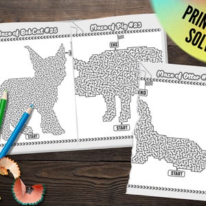 May include: A collection of three black and white maze puzzles featuring a bobcat, pig, and otter. The puzzles are labeled with numbers and start/end points. Colored pencils and a pencil sharpener are scattered around the pages. The text "PRINT AND SOLVE" is visible.