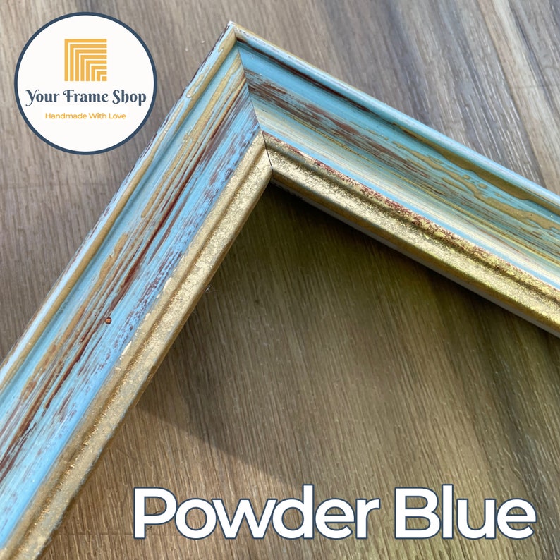 Puede incluir: Primer plano de una esquina de un marco de imagen azul y dorado con un acabado desgastado. El marco est&aacute; hecho de madera y tiene un aspecto r&uacute;stico. El texto "Powder Blue" es visible en la parte inferior de la imagen.