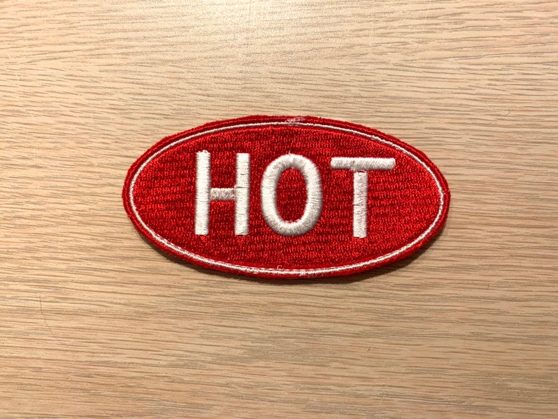 May include: Red oval patch with white embroidered text that reads "HOT".