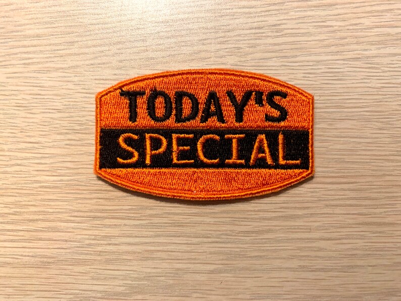 May include: Orange embroidered patch with black text that reads "TODAY'S SPECIAL".