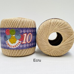 May include: Two spools of beige crochet thread, labeled "Crochetta 10 100% Cotton".