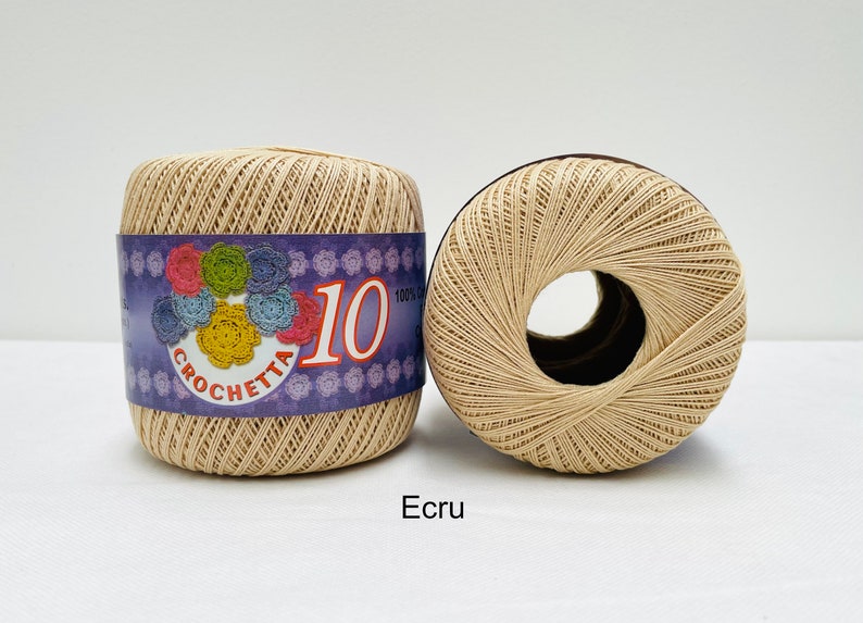May include: Two spools of beige crochet thread, labeled "Crochetta 10 100% Cotton".