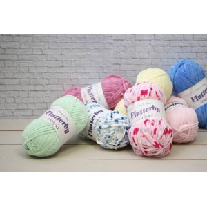 Pu&ograve; includere: Assortimento di gomitoli di lana colorati in vari motivi, tra cui rosa, blu, verde e giallo. La lana &egrave; etichettata "Flutterby Chunky" ed &egrave; realizzata da James C Brett.