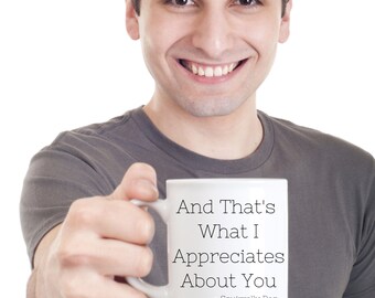 Könnte beinhalten: Eine weiße Keramiktasse mit dem Text "And That's What I Appreciates About You - Squirrelly Dan" darauf. Eine Person hält die Tasse und lächelt in die Kamera.